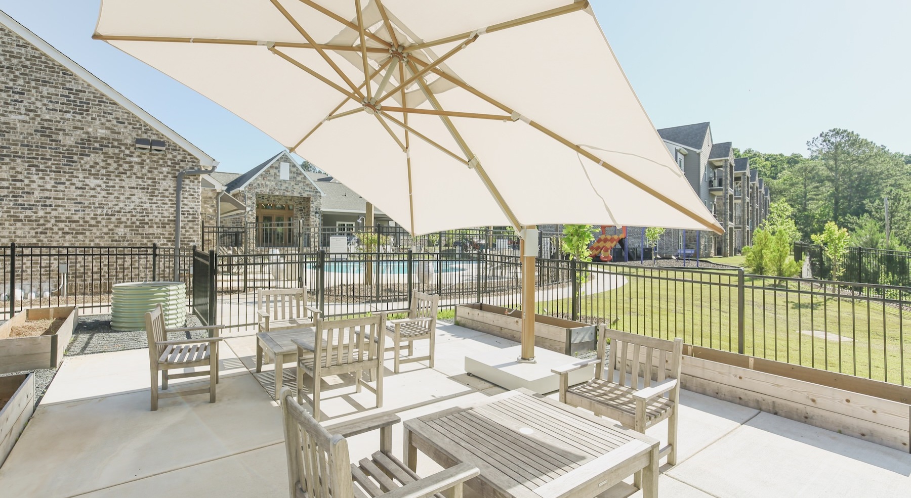 a patio with tables, chairs and an umbrella