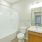Bathroom with toilet, tub, and orange cabinets